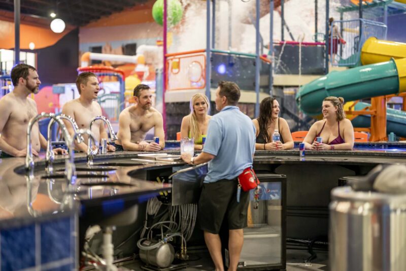 Multiple adults hang out at the AstroBar - our swim-up bar inside Blast Off Bay, where you can purchase and enjoy adult beverages!